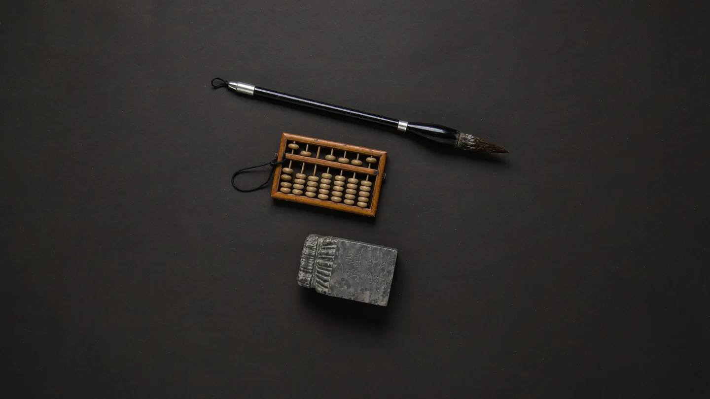 Ink-wash artwork of a brush, an abacus and a seal arranged as tools